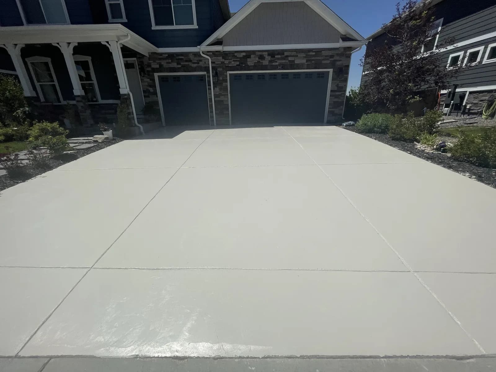 Freshly coated concrete driveway at a two-car garage