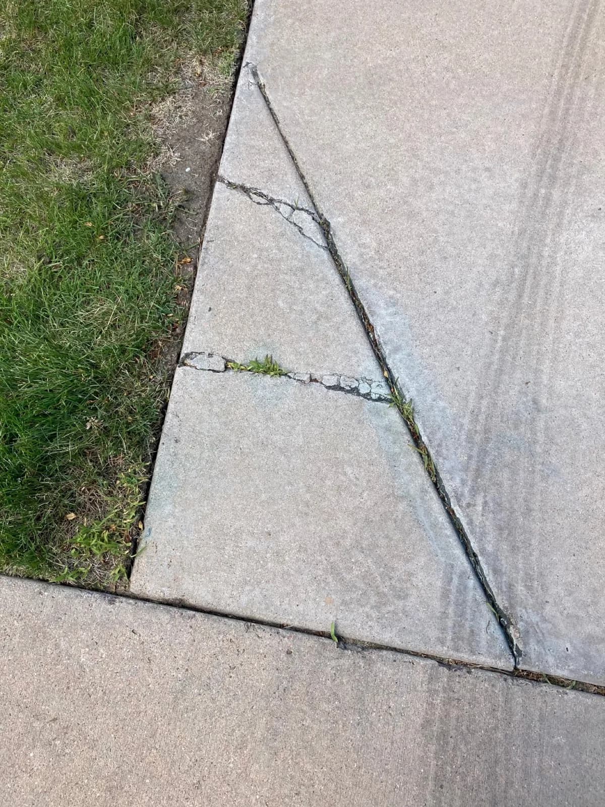 Cracked concrete sidewalk documented before repair